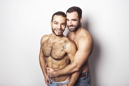 Young homosexuals gay couple love each other on a white background.の写真素材