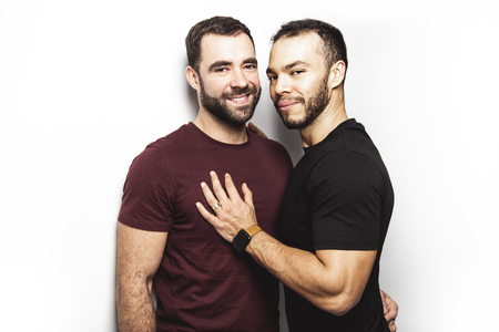 Young homosexuals gay couple love each other on a white background.の写真素材