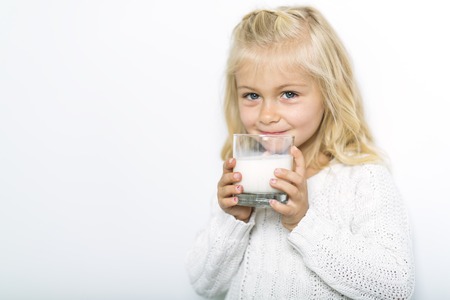 Cute girl 4-5 year old posing in studio with milkの写真素材