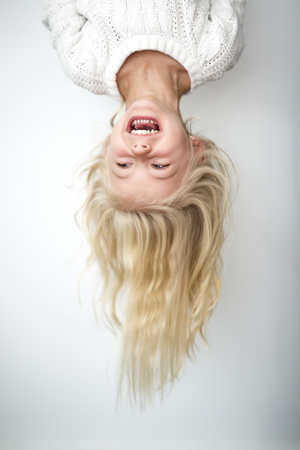 Cute girl 4-5 year old posing in studio upside downの写真素材