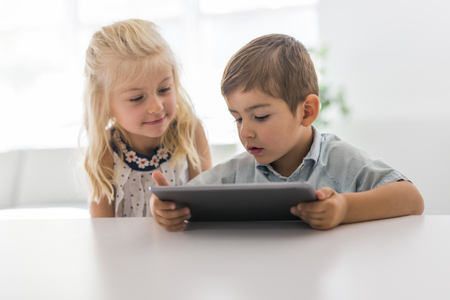Adorable brother and sister young child using tabletの写真素材