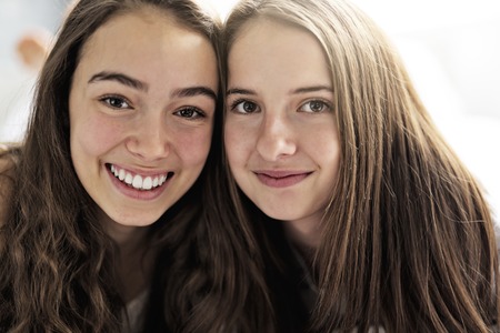 Friends in pajamas sitting in bed at home relaxing.の写真素材