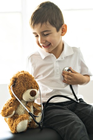 A doctor boy playing and cure bear at the pediatric