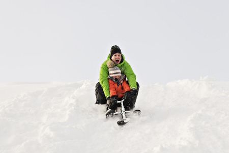 A nice Father And Son Sitting On Sledge