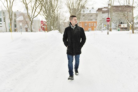 Beautiful winter portrait of a handsome man in a knitted hatの写真素材
