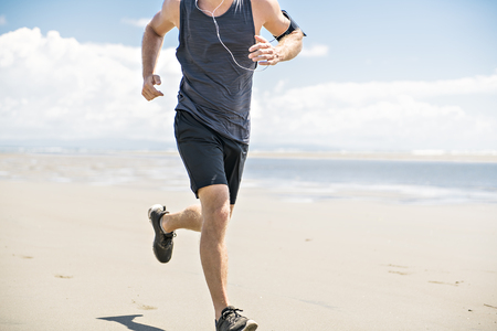 A Men jogging on day time on the beachの写真素材