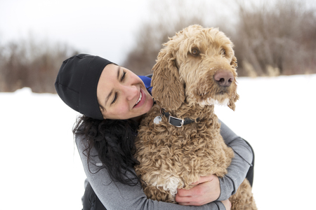 A nice Woman with goldendoodle winter season