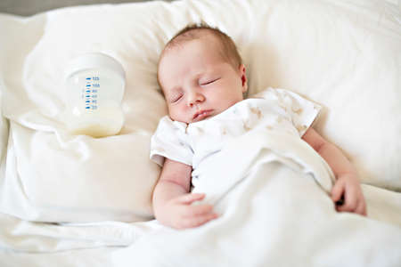 A Sweet newborn baby girl sleeping in white bed