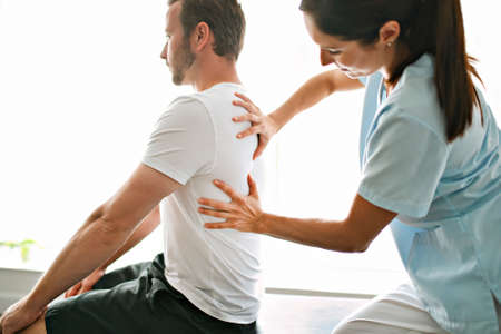physiotherapist doing treatment with patient in bright office