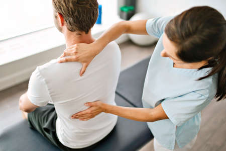 physiotherapist doing treatment with patient in bright office
