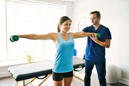 Male Physical Therapist Stretching a Female Patient Slowly.