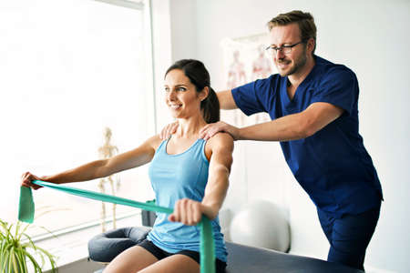 Male Physical Therapist Stretching a Female Patient Slowly.