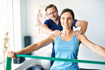 Male Physical Therapist Stretching a Female Patient Slowly.