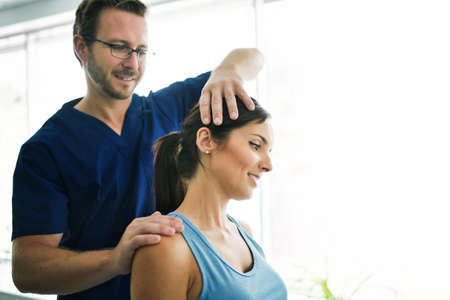 Male Physical Therapist Stretching a Female Patient nack