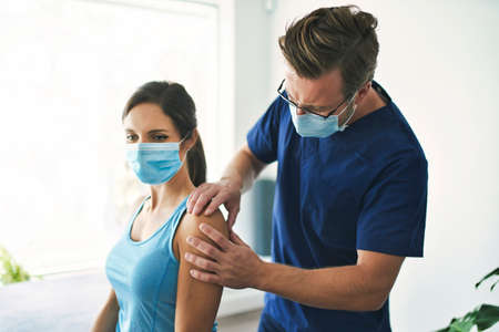 Male Physical Therapist Stretching a Female Patient Slowly.の写真素材