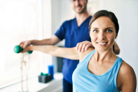 Male Physical Therapist Stretching a Female Patient Slowly.