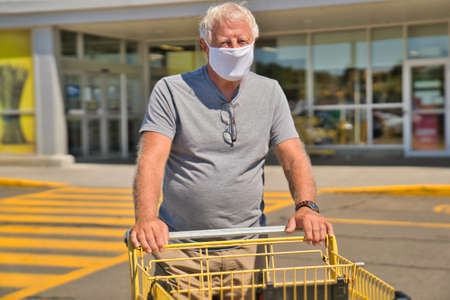 Senior man shopping at the supermarket with mask
