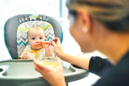 A happy little cute daughter with mash food everywhereの写真素材