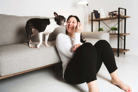 Woman with is Boston Terrier on the living room