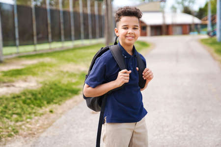 The Great Portrait Of School Pupil Outside Classroom Carrying Bagsの写真素材