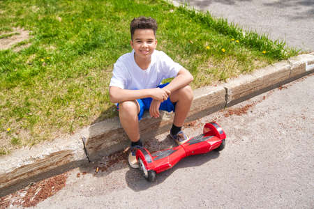 Beautiful Portrait of a Black Boy Running a Mini Electric Scooter