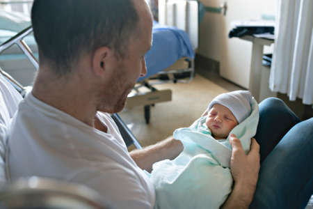 Father with her newborn baby at the hospital a day after birthの写真素材