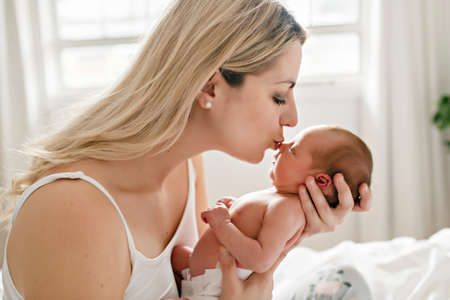 A woman with a newborn baby in bedの写真素材