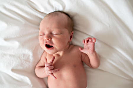A cute Newborn baby crying in bedの写真素材