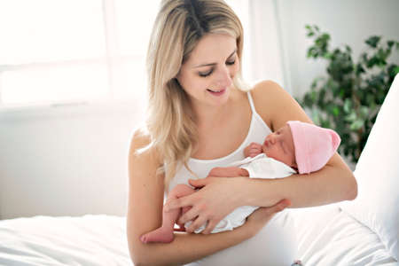 A woman with a newborn baby in bed