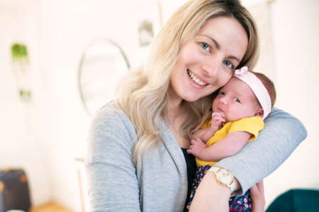 Portrait of happy mother and baby at home
