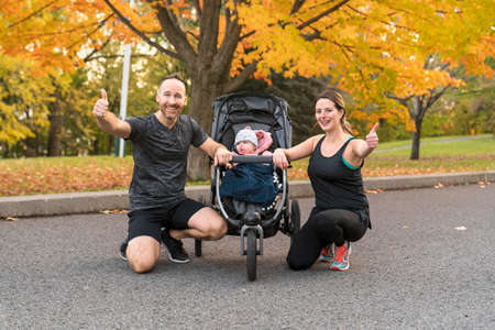 A jogging couple with stoller on autumn season