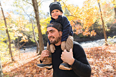 Happy family father and child boy in the autumn leaf fall in park