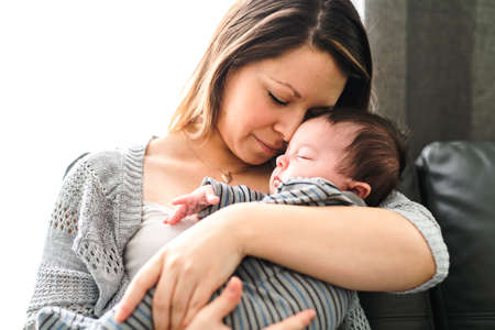 Mother with baby having greet time on the sofa at homeの写真素材