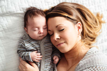 Mom and Baby having wonderful time on bed on the morningの写真素材