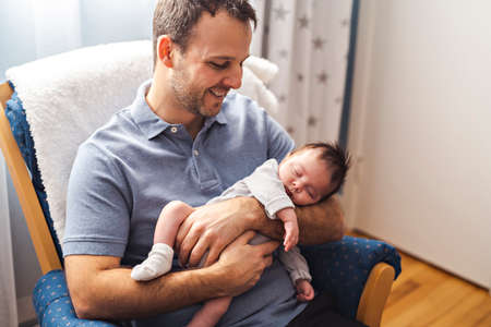 Father and Baby having wonderful time sit on chair one the bedroomの写真素材