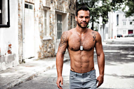 A sexy man outside in a city street