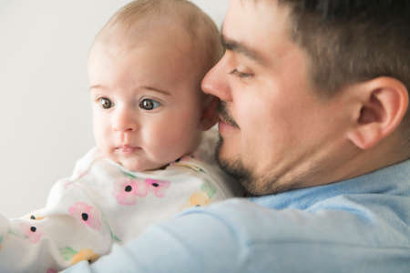 Young daddy with his daughter in his arms on the baby room