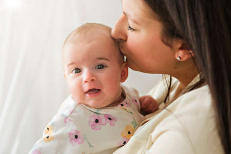 family mother playing with newborn baby on the baby roomの写真素材