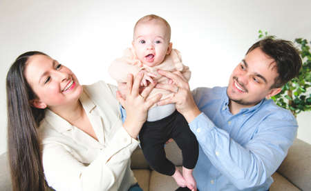 A nice family with baby girl on the sofa