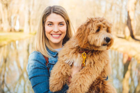 Happy Labradoodle Dog and woman outside at the park