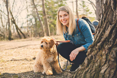 Happy Labradoodle Dog and woman outside at the park