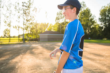 A children baseball players standing on the playgroundの写真素材