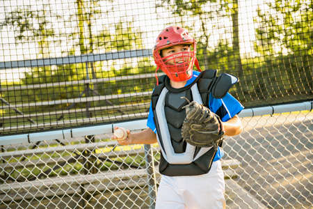 A children baseball catcher players standing on the playgroundの写真素材