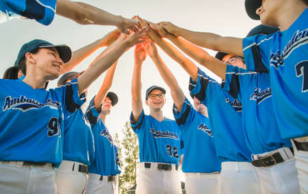 Group of baseball players standing together on the playground with hand overの写真素材