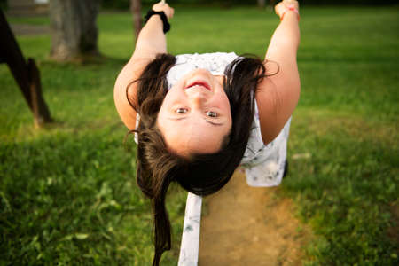 A portrait of trisomie 21 adult girl outside at sunset having fun on a park