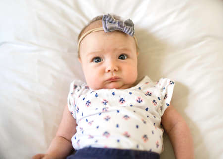 happy newborn baby on the bed wearing cute clothes