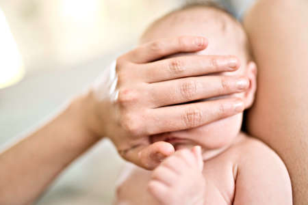 mother hidden baby eye with his handの写真素材