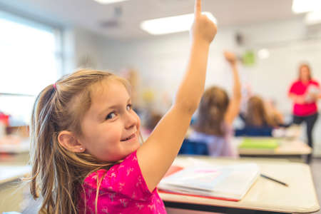 education and school concept little student girl studying at school hand high