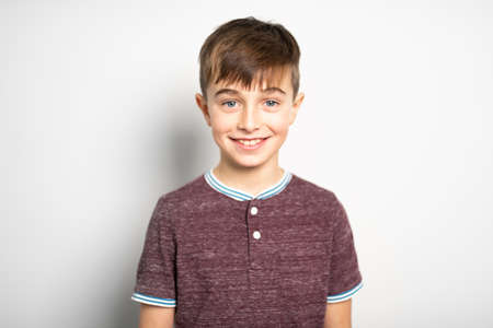 A portrait of young boy over white wall