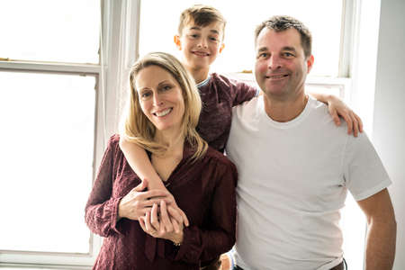 A couple with the child boy close to the window
